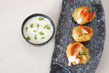 Sabudana vada or Sago fried fitters served with Curd or yogurt and ketchup over white wooden background, popular fasting recipe from India or mostly eaten during Fasting