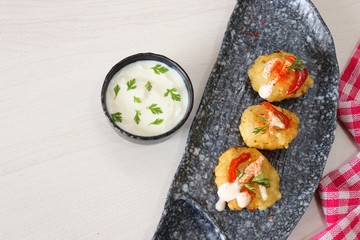 Sabudana vada or Sago fried fitters served with Curd or yogurt and ketchup over white wooden background, popular fasting recipe from India or mostly eaten during Fasting