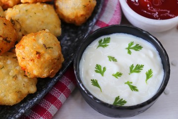 Sabudana vada or Sago fried fitters served with Curd or yogurt and ketchup over white wooden background, popular fasting recipe from India or mostly eaten during Fasting