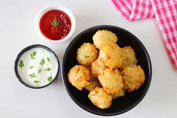 Sabudana vada or Sago fried fitters served with Curd or yogurt and ketchup over white wooden...