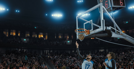 Basketball players on big professional arena during the game. Tense moment of the game. Celebration