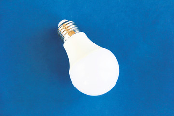 white round glass light bulb on a blue background