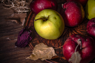 Fresh autumn apples on rural wooden background, natural rough fruit surface