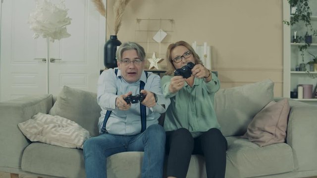 Aged man and woman are playing a videogame
