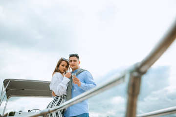 Newlyweds in love on sail boat with champagne - Happy exclusive alternative lifestyle concept. Couple celebrating with champagne on a boat having party with girlfriend on vacation.