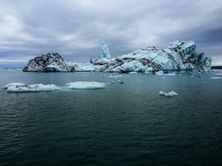 Icebergs with volcanic ash layers floating on water in a glacier lagoon