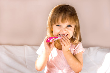 Happy baby girl brushing her teeth. Oral hygiene concept. Place to insert text