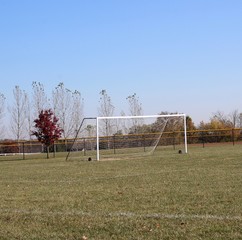A side view of the white soccer goal net in the field.