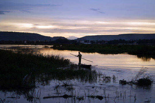 Malian Fisherman Poling His Boat Along The niger Riverside In The late Evening