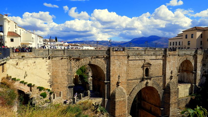 neue Brücke in Ronda spannt ich über tiefes Tal unter lebhaften weißen Wolken und blauem Himmel