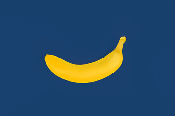 toy yellow plastic banana on blue colored background