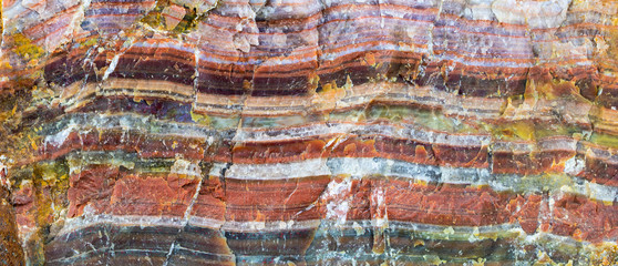 A large piece of raw agate. The semi-precious stone is banded and shows many, intense colors. Concept: rocks and minerals