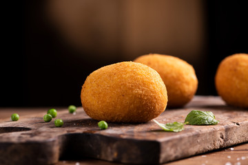 Arancini rice balls. Fried rice balls on brown wooden background. Snack, street food