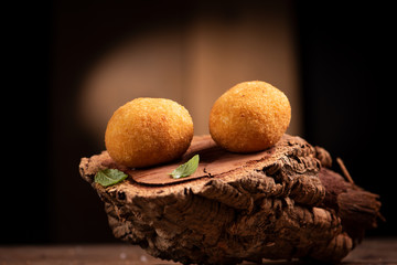 Arancini rice balls. Fried rice balls on brown wooden background. Snack, street food