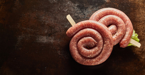 Coils of spicy raw sausage in a panorama banner