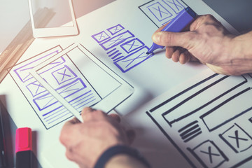 ux graphic designer sketching wireframe for mobile app and website development