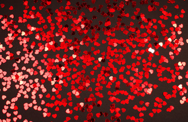 Fototapeta na wymiar Valentine's day red hearts glitter on black background, holyday background