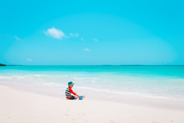 Fototapeta na wymiar little boy play with toys and sand on beach
