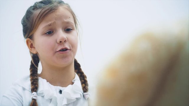 Cute little girl sitting, talking with her teddy, berating it, shaking her finger.