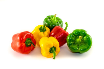Pile of bell peppers isolated on white background. Red, green and yellow colored bell peppers.