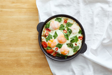 top view of fried eggs on napkin on wooden table