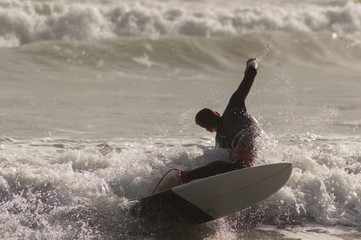 Caucasian boy with a black neoprene prepared to surf .