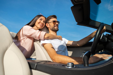 low angle view of attractive woman and handsome man riding in convertible