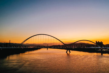 Fototapeta premium Crescent Bridge - landmark of New Taipei, Taiwan with beautiful illumination at day, aerial photography in New Taipei, Taiwan.