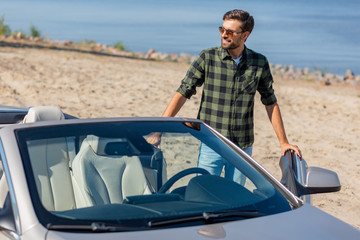 smiling guy open door of convertible to sit in