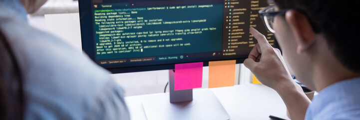 Young startup Programmers Sitting At Desks Working On Computers screen for Developing programming and coding to find solution to problem on New Application.