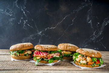 Various seafood and fish burgers assortment. Homemade healthy burger with grilled prawn, salmon,...