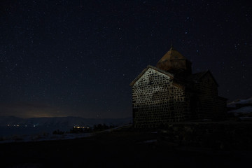 Sevanavank on the background of the night starry sky. Sevanavank is a monastic complex located on a peninsula at the northwestern shore of Lake Sevan