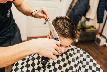 man getting trendy haircut at barber shop