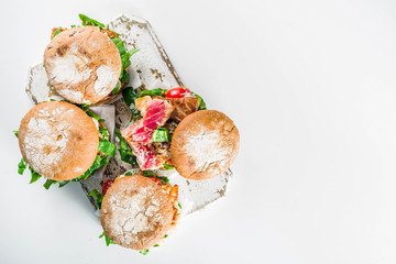 Various seafood and fish burgers assortment. Homemade healthy burger with grilled prawn, salmon, tuna, sea bass, fresh herbs, mozzarella cheese and baby spinach.