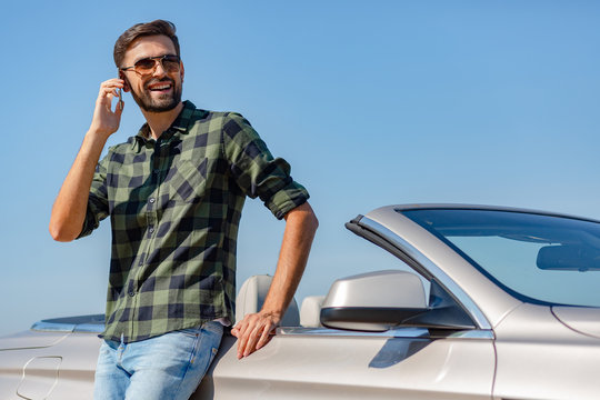 Caucasian Man Leaning The Car And Talking On Smartphone