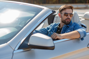 portrait of handsome man riding auto and looking away