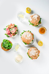 Various seafood and fish burgers assortment. Homemade healthy burger with grilled prawn, salmon, tuna, sea bass, fresh herbs, mozzarella cheese and baby spinach.
