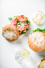 Various seafood and fish burgers assortment. Homemade healthy burger with grilled prawn, salmon, tuna, sea bass, fresh herbs, mozzarella cheese and baby spinach.