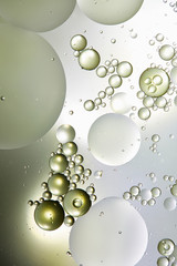 abstract background from mixed water and oil bubbles in light green and grey color