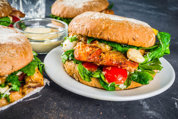 Various seafood and fish burgers assortment. Homemade healthy burger with grilled prawn, salmon, tuna, sea bass, fresh herbs, mozzarella cheese and baby spinach.