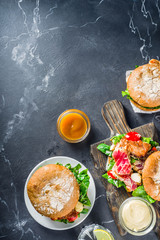 Various seafood and fish burgers assortment. Homemade healthy burger with grilled prawn, salmon, tuna, sea bass, fresh herbs, mozzarella cheese and baby spinach.