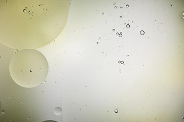 Beautiful background from mixed water and oil bubbles in light green and grey color