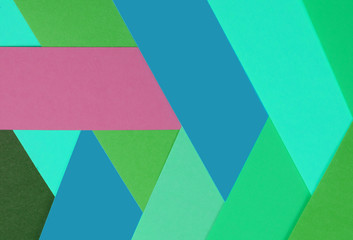 Layers of colored, rough textured construction paper creating a graphic template. Abstract design geometric style color blocks. Copyspace. Cool tones with pink pop.