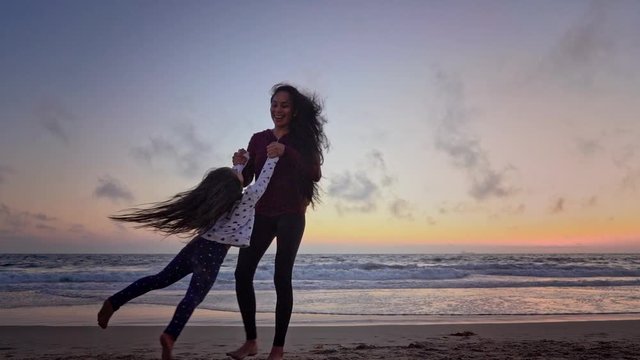 Mother and Daughter Playing on the Beach at Sunset