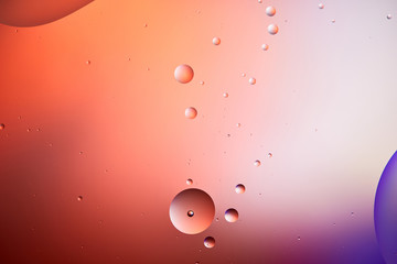 abstract creative background from mixed water and oil bubbles in red and purple color