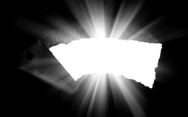 A hole in black paper with torn edges and piercing sunlight and rays through it. Sunlight breaking...