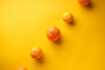 Orange tangerines on a yellow background with place for text. Flat lay.