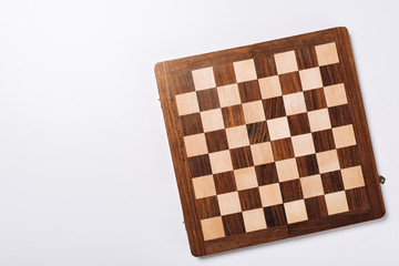 Top view of checkerboard on white background with copy space
