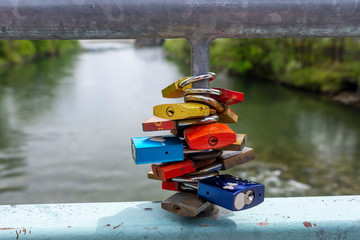 Padlock on a bridge with a river of focus in background.