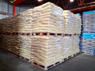 Chemical fertilizers Packed in stacked sacks with clear plastic wrapped around stacked on wooden pallets orderly. In the warehouse waiting for delivery